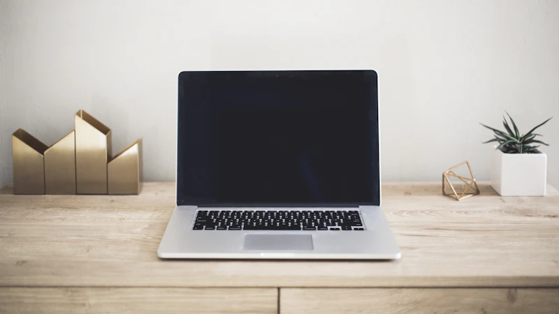 Een laptop op een houten bureau.